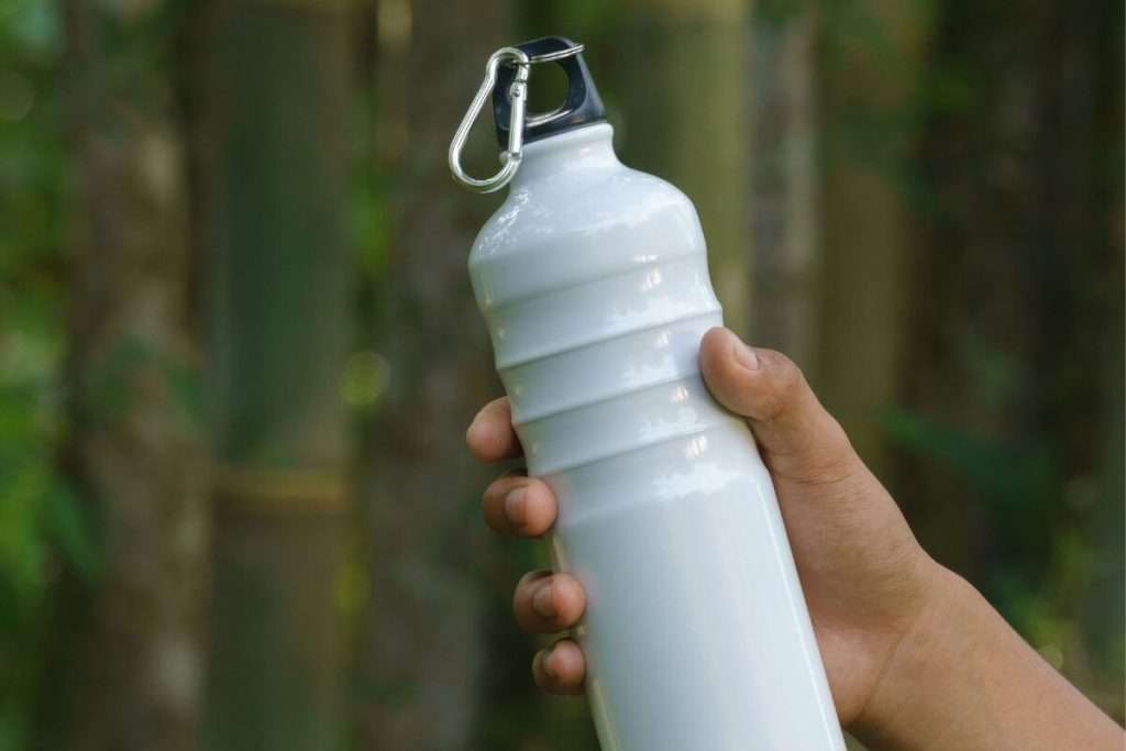 Una persona sosteniendo una botella de agua.