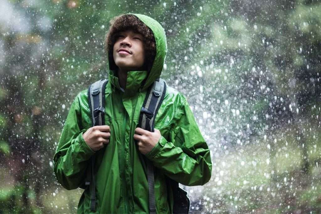 Un excursionista con un chubasquero bajo la lluvia.